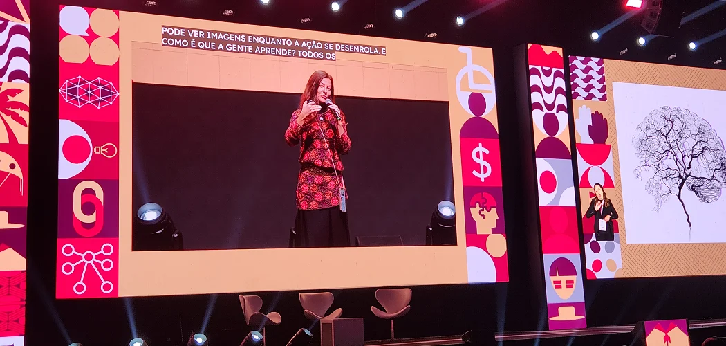 Palco de evento com intérprete de Libras e legendas em tempo real exibidas nos telões
