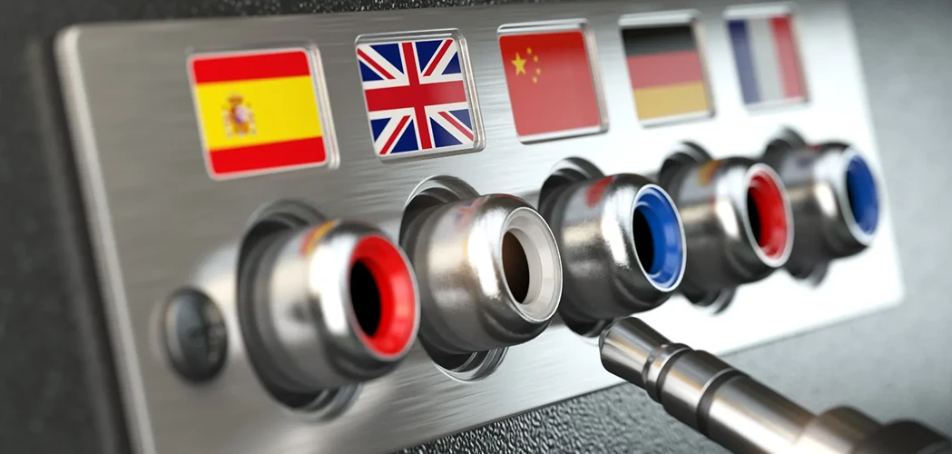 Imagem de um painel com várias entradas de áudio, cada uma identificada por uma bandeira nacional. Da esquerda para a direita, aparecem as bandeiras da Espanha, Reino Unido, China, Alemanha e França.