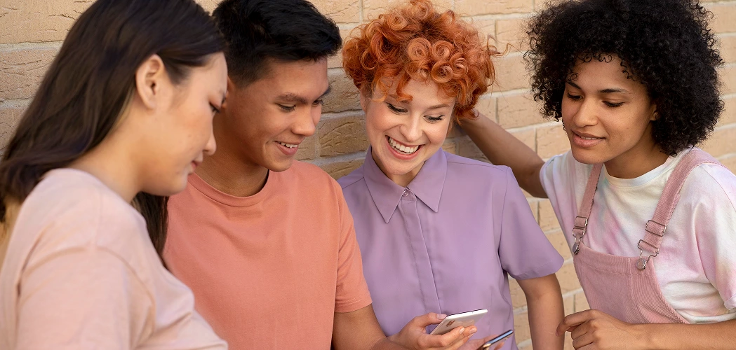Pessoas sorridentes olhando para um celular